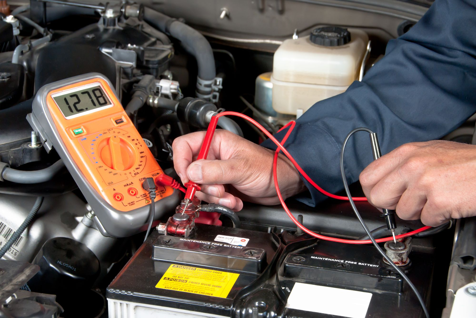Car battery voltage being tested with a multimeter to diagnose cold weather battery issues.